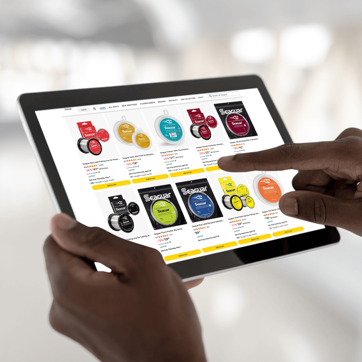 Image of hands holding an iPad showing the Amazon Seaguar fluorocarbon finishing lines from Seaguar's store.